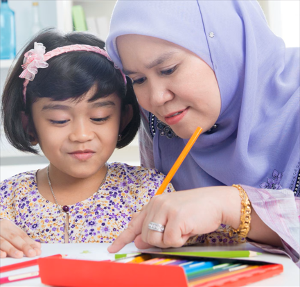 Ibu membimbing anak membuat latihan Bahasa Inggeris